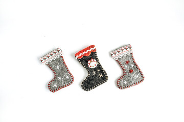 Three felt Christmas socks, stockings on white background. Craft felt handmade Christmas decorations
