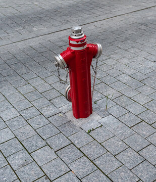 Fire hydrant red color on a cobblestone background.