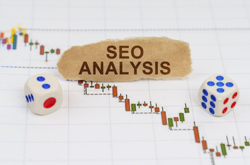 On the trading charts, there are dice and pieces of paper with the inscription - SEO ANALYSIS
