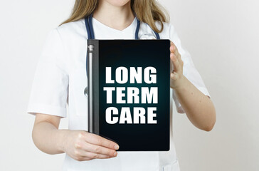The doctor is holding a tablet with the inscription - LONG TERM CARE