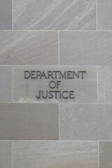 Department of justice sign on stone wall in Washington DC, USA