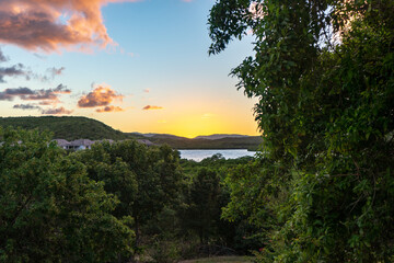 View of leafy Nonsuch Bay during sunset, reflected in still pool. Antigua, Caribbean