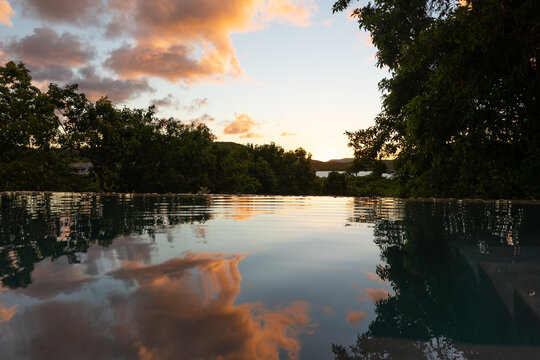 View of leafy Nonsuch Bay during sunset, reflected in still pool. Antigua, Caribbean