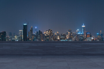Fototapeta premium Panoramic Bangkok skyline view, concrete observatory deck on rooftop, night time. Asian corporate and residential lifestyle. Financial city downtown, real estate. Product display mockup empty roof