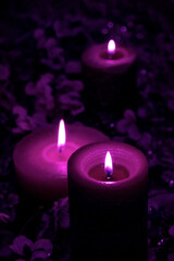 Obraz na płótnie Canvas candle burn black background light a lot violet velvet purple blue