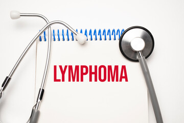 White notepad with the words lymphoma and a stethoscope on a blue background. Medical concept