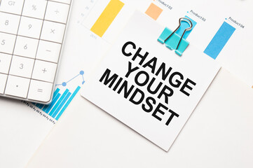 CHANGE YOUR MINDSET text concept. Office workplace table with calculator, graphs, reports and the text Budget 2021 on a small piece of paper on multicolored background.