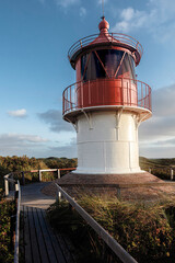 Red and white building of naval lighthouse. Formerly used for ship navigation.