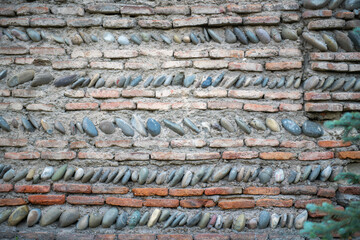 the wall is made of concrete and smooth stones