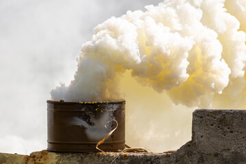 The fuming smoke grenade on a destroyed brick wall during tactical training. Used as a signaling...