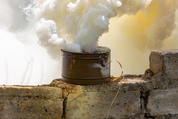 The fuming smoke grenade on a destroyed brick wall during tactical training. Used as a signaling...