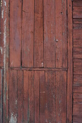 Old wooden wall with remnants of red paint. Texture of old wooden boards.