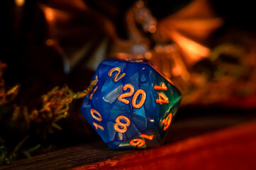Close-up image of a blue d20 in warm light