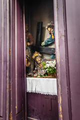 Statues stored behind a door in a small altar