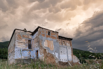 Clouds and cumulus in stormy sky with abandoned house in the countryside, gloomy