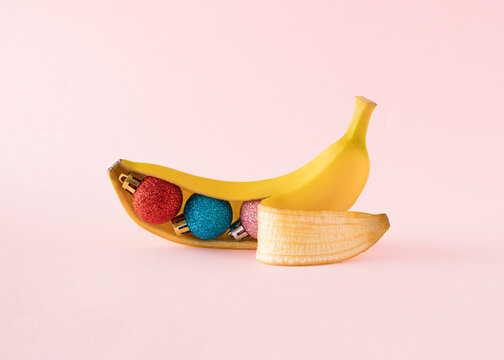 Humorous New Year&rsquo;s and fruit concept. Colorful Christmas balls in banana under the peel
