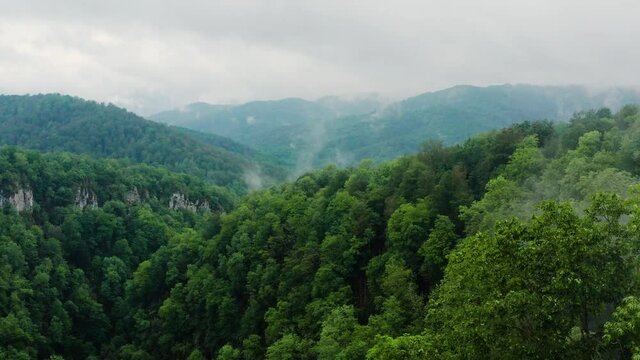 Caucasus Mountains, Akhun mountain range. Navalishinsky Canyon (White rocks). The valley of the Bolshaya Khosta River in fog. Aerial view.