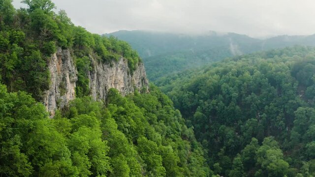 Caucasus Mountains, Akhun mountain range. Navalishinsky Canyon (White rocks). The valley of the Bolshaya Khosta River in fog. Aerial view.