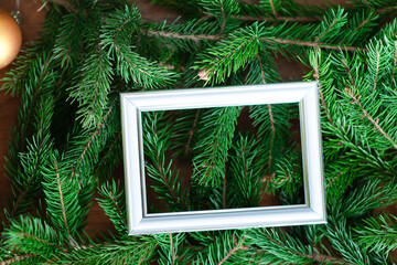 Background from green fir branches and white frame for design of greeting cards of the celebration of Christmas and New Year.	