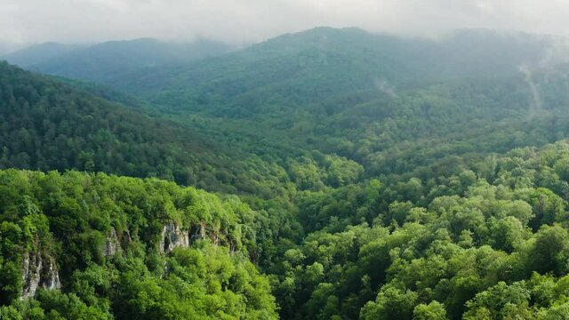 Caucasus Mountains, Akhun mountain range. Navalishinsky Canyon (White rocks). The valley of the Bolshaya Khosta River in fog. Aerial view.