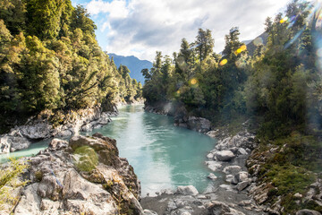 Naklejka na ściany i meble The vibrant blue water of the river flowing through the Hokitika gorge.