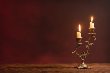A burning candle on the table front view background with copy space.