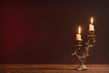 A burning candle on the table front view background with copy space.