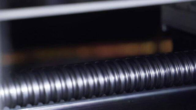 Threaded metal rod rotates. Moving parts of iron machine close up