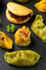 Dim Sum dumplings and Bao buns on rustic stone board. Traditional Chinese food