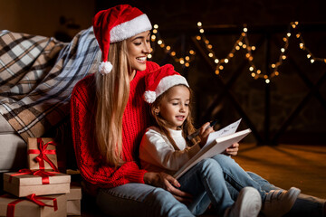 Obraz na płótnie Canvas Cute girl and happy woman writing letter to Santa