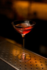 Close-up angle view on beautiful glass of cocktail on steel bar surface