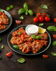 Greek tomato fritters, tomatokeftedes served with yogurt on plate.