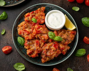Greek tomato fritters, tomatokeftedes served with yogurt on plate.