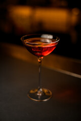 Selective focus on beautiful glass on long leg with bright red drink on the table