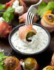 Streaky bacon wrapped Brussel sprouts with yogurt herb sauce. party food.