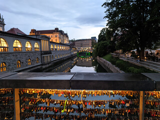 Locks on a bridge above romantic Ljubljanica river bank in Ljubljana city center at night. Cozy...
