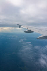 Fototapeta premium View from the airplane window at a beautiful blue sunrise and the airplane wing in clear sky.