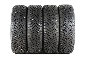 Four new winter car tires with spikes on a white background. Isolated