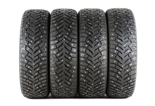 Four new winter car tires with spikes on a white background. Isolated