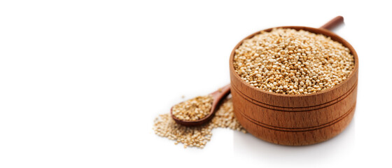 Quinoa White grains in a wooden bowl and spoon. Gluten free Healthy food. Diet, dieting concept. Seeds of white quinoa - Chenopodium quinoa isolated on white background, close up. Healthy Vegan food 