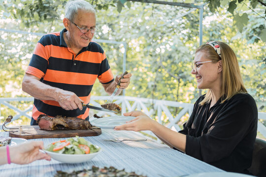 Positive family having lunch during summer holidays in countryside