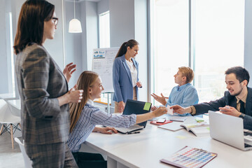 Coworkers discussing business ideas while working in office