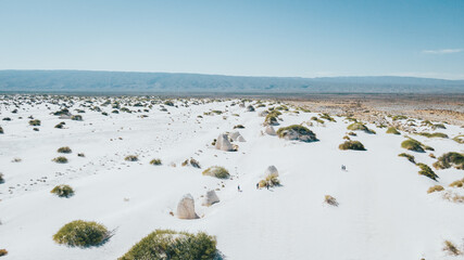 Amazing landscape with gypsum dunes in the middle of the desert with shades in the white and green sand of the little vegetation, mountains, and the wide desert are distinguished.