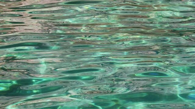 Emerald sea water in sunshine glow as surface background. Summer holidays and coastal nature concept. High quality 4k footage