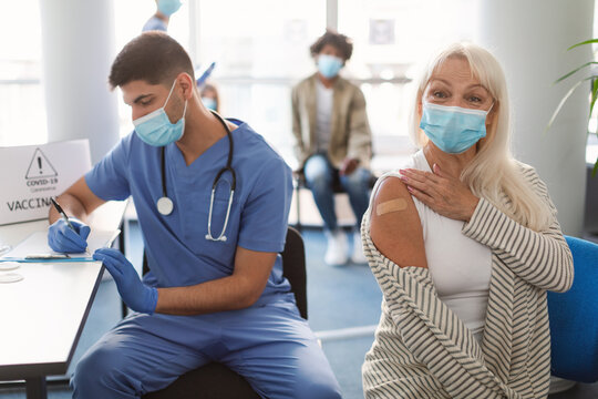 Happy Mature Woman Showing Hand With Patch After Vaccine
