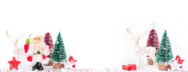 Santa, Christmas deer and festive decorations on table. Christmas still life web banner