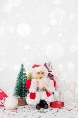 Santa, Christmas deer and festive decorations on table. Christmas still life web banner