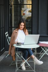 Happy Nice Woman Working on Laptop in Street Cafe