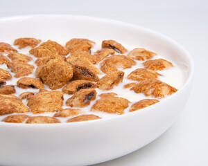Crispy pads chocolate pillows with milk in dish isolated on the white background
