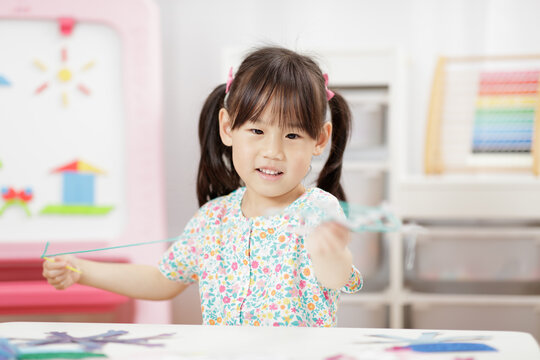 young girl making snowflakes craft for home schooling